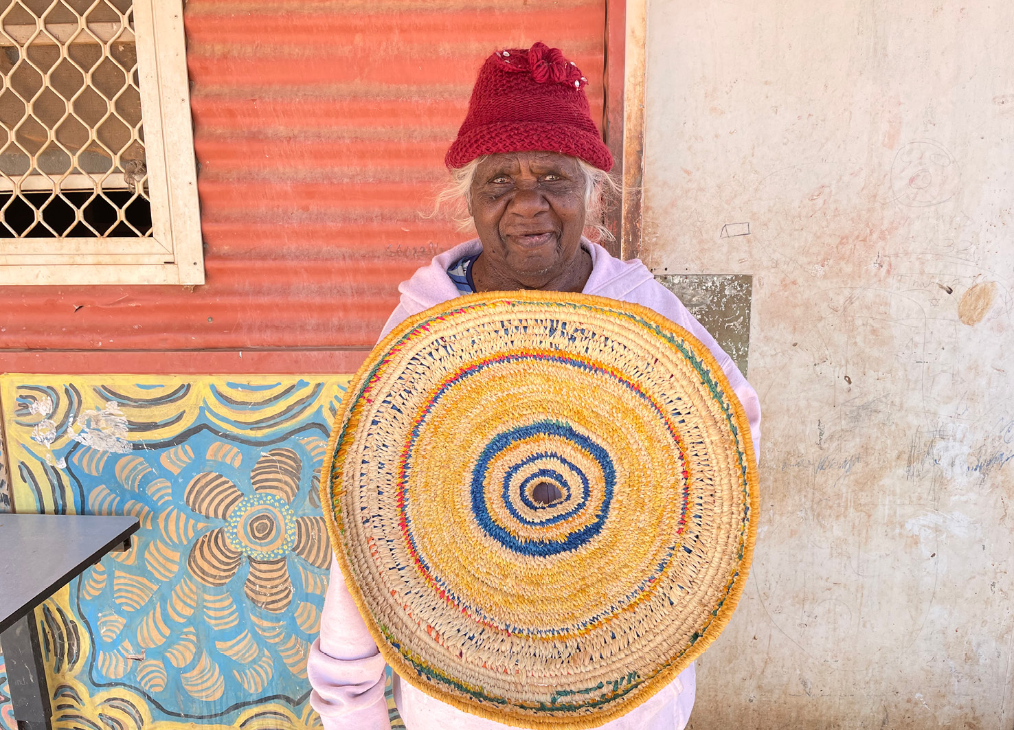 Betty Muffler with her basket, Raffia, 70cm, 2021. Photo by Emma Franklin and courtesy of Tjanpi Desert Weavers