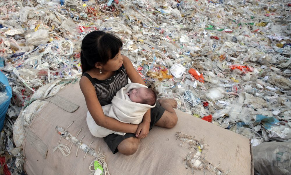 Plastic China documentary – girl sitting on a pile of recycling